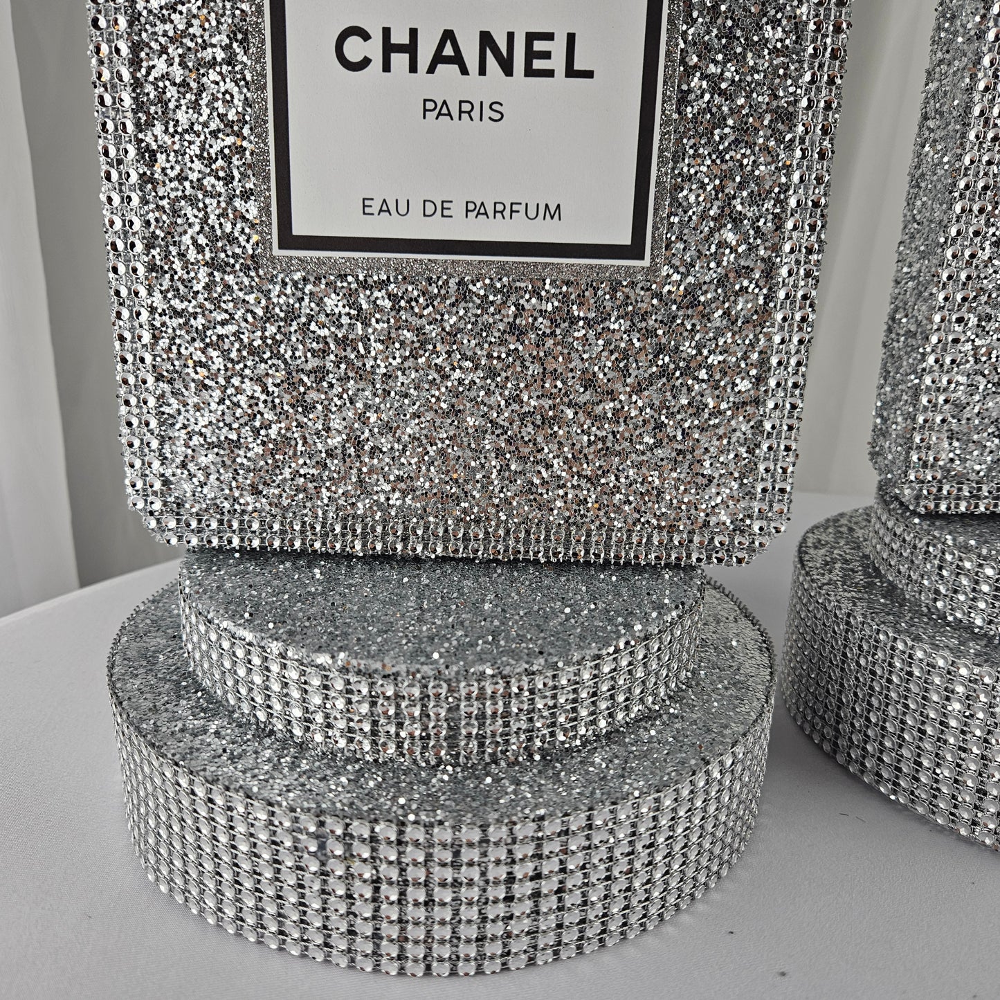 Size view of Chanel inspired silver perfume centerpiece for party table