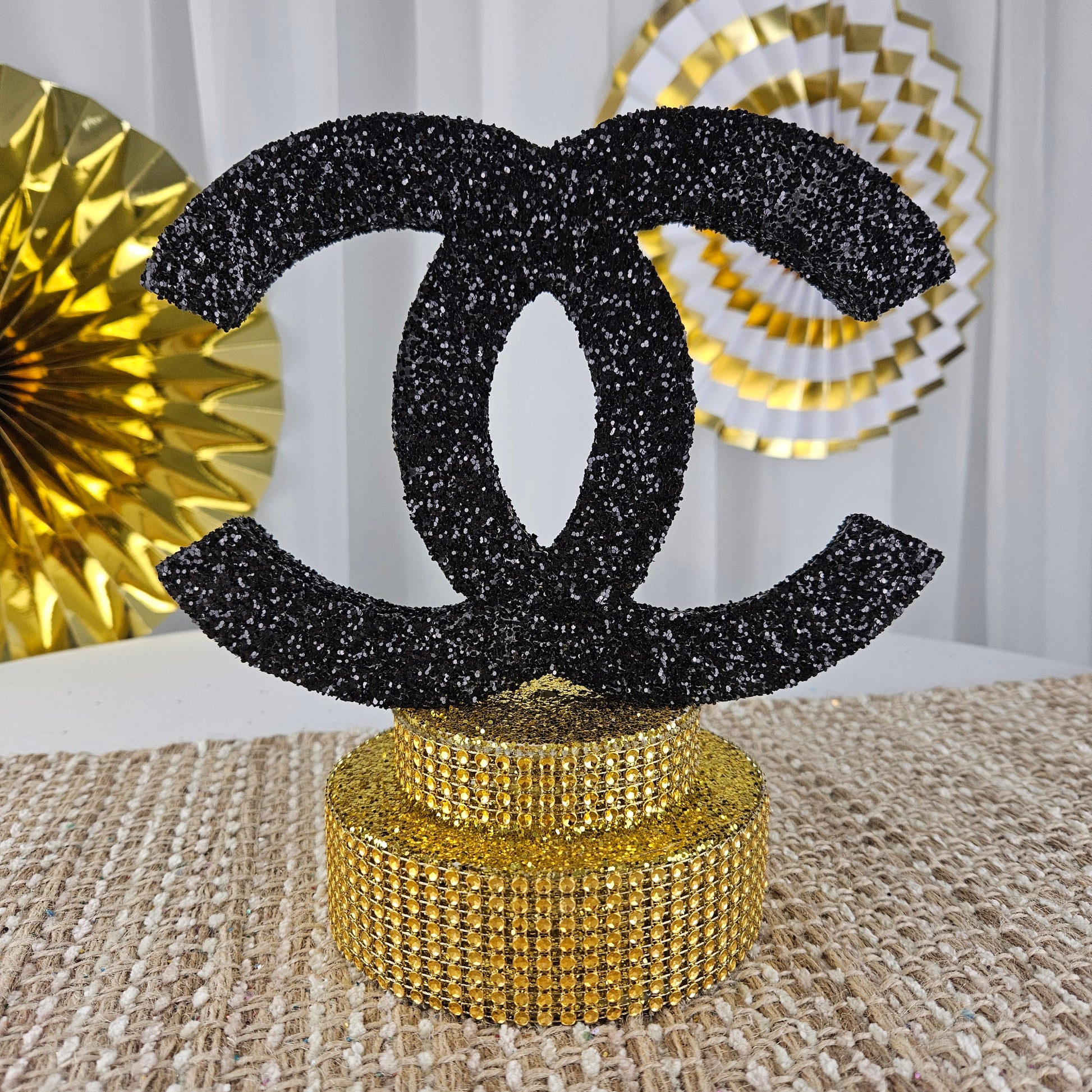 Chanel-inspired birthday centerpiece with gold glam base for stylish parties