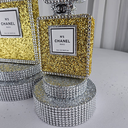 gold chanel birthday decorations Close up glitter detail on gold and silver Chanel perfume bottle centerpiece for upscale birthday party decor