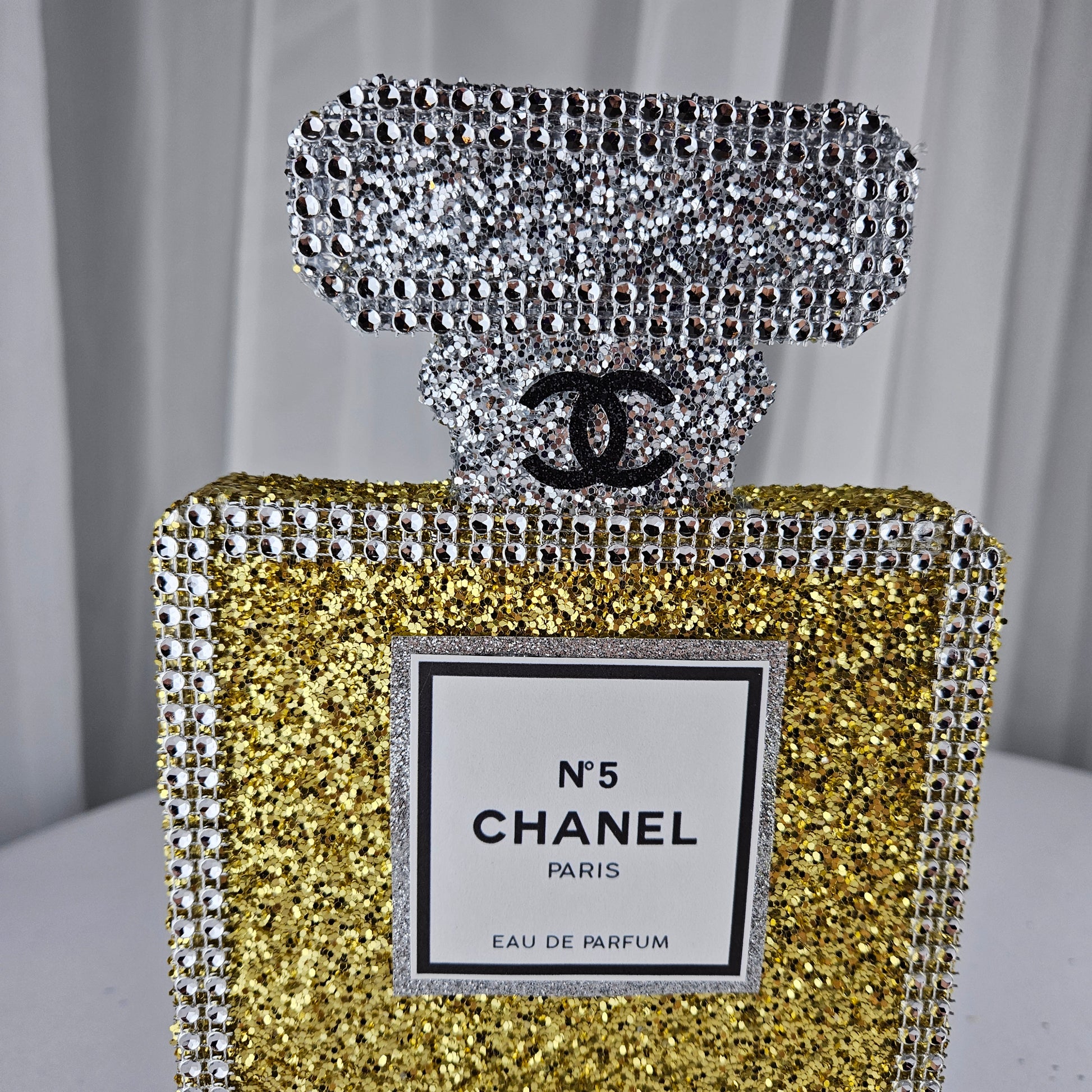 gold chanel birthday decorations Gold and silver Chanel perfume bottle party centerpiece styled on table for Paris themed birthday party