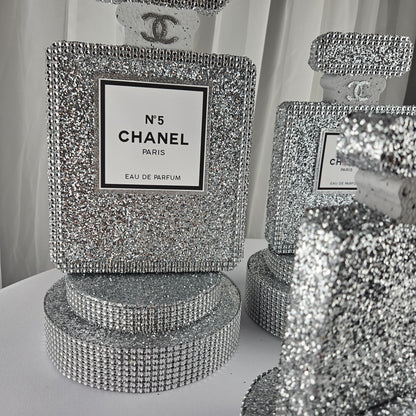 Angled view of Chanel inspired silver perfume centerpiece for glam party decor