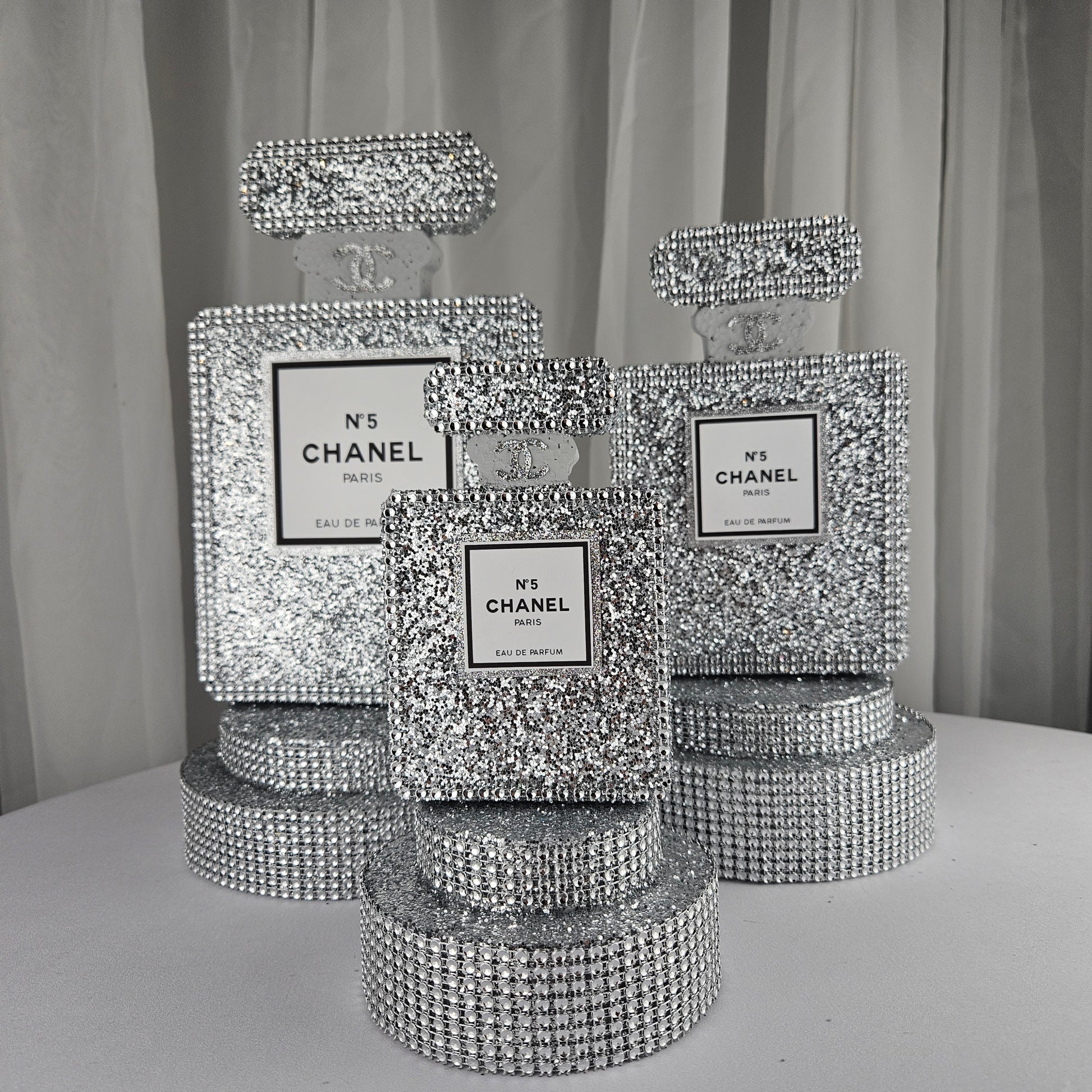 Front view of silver Chanel inspired perfume centerpiece for luxury birthday decorations