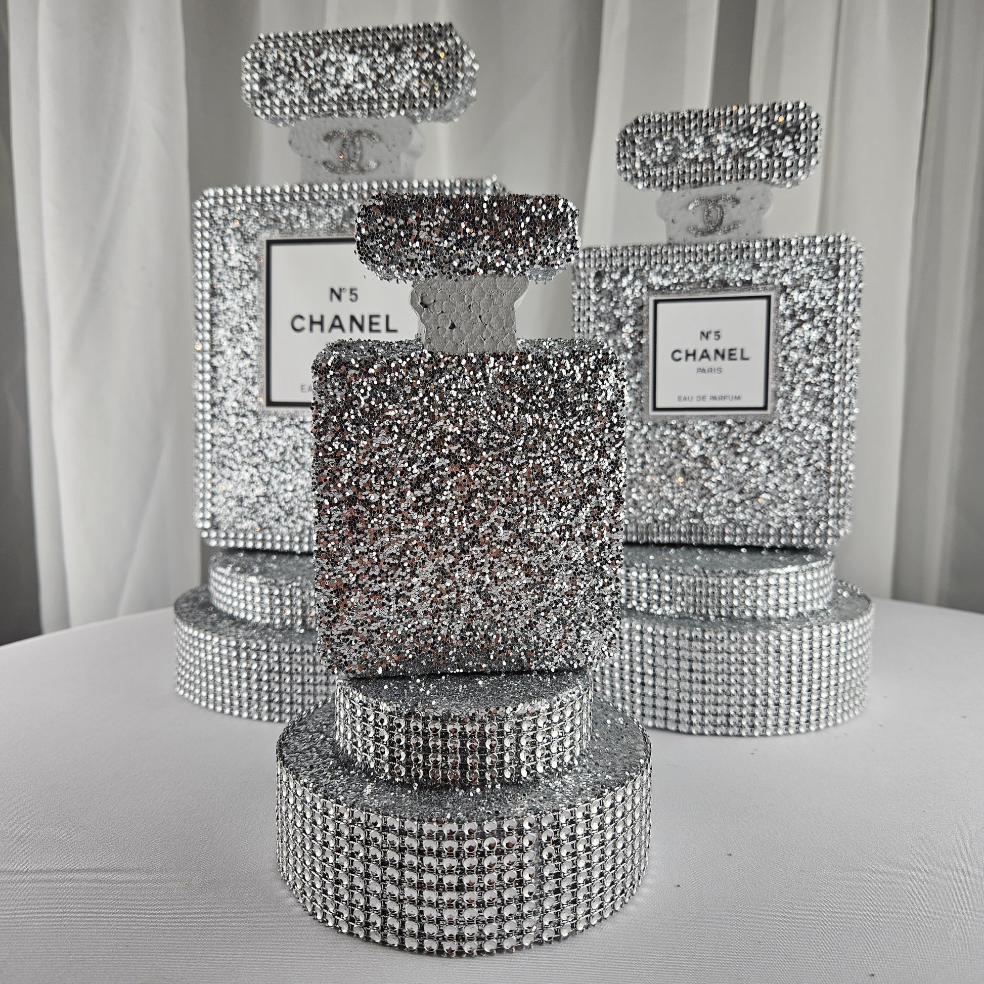 Silver Chanel inspired perfume centerpiece styled on table for Paris themed party

