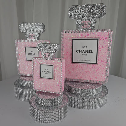 Front view of pink and silver Chanel inspired perfume centerpiece for luxury birthday decorations

