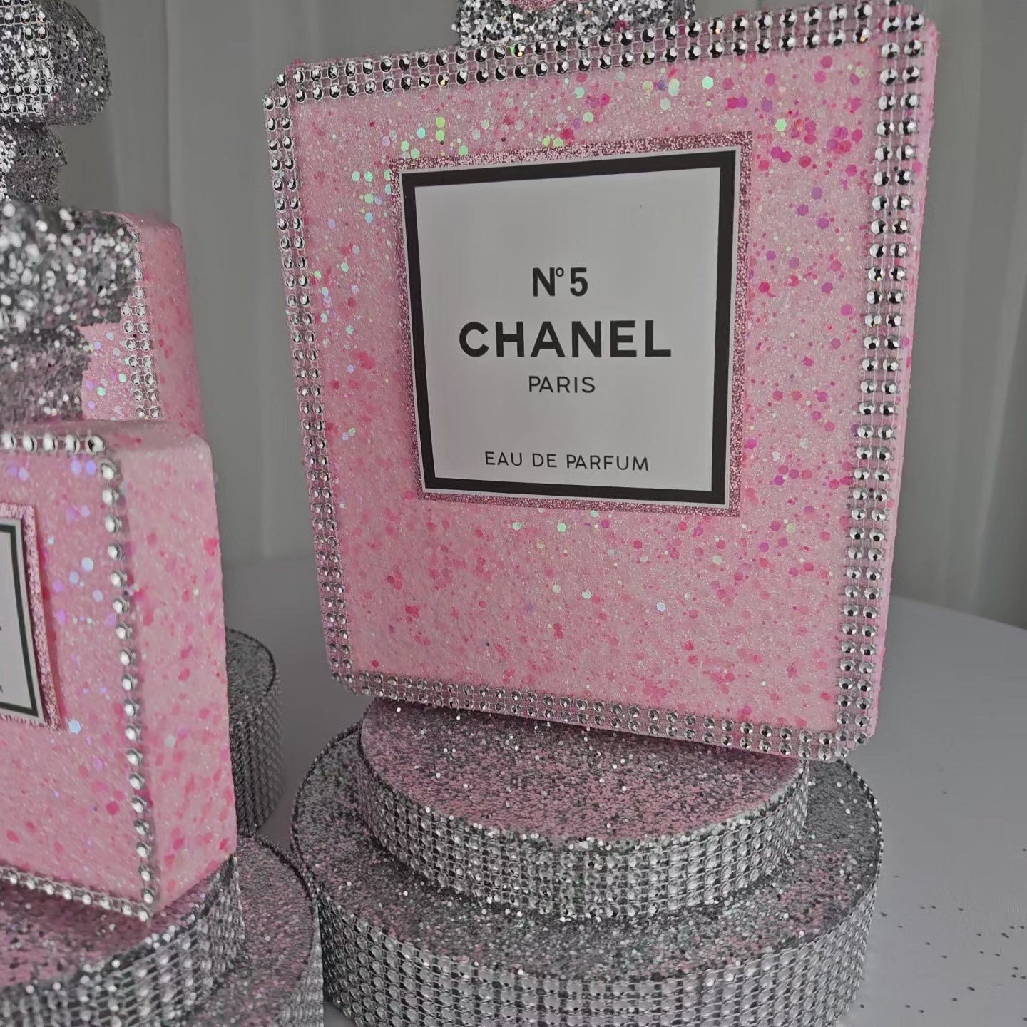 Pink and silver Chanel inspired perfume centerpiece styled on table for Paris themed party