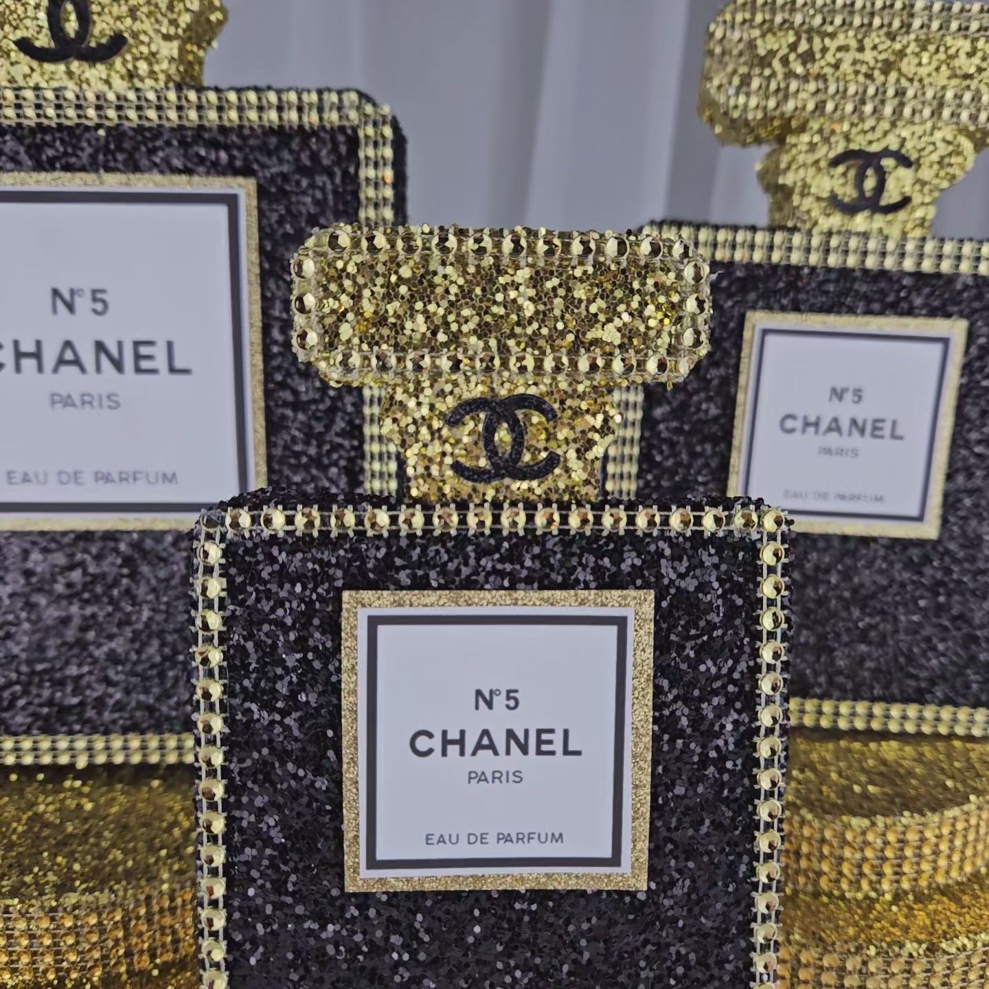 Glam Chanel-style perfume bottle centerpiece for luxury birthday celebrations
