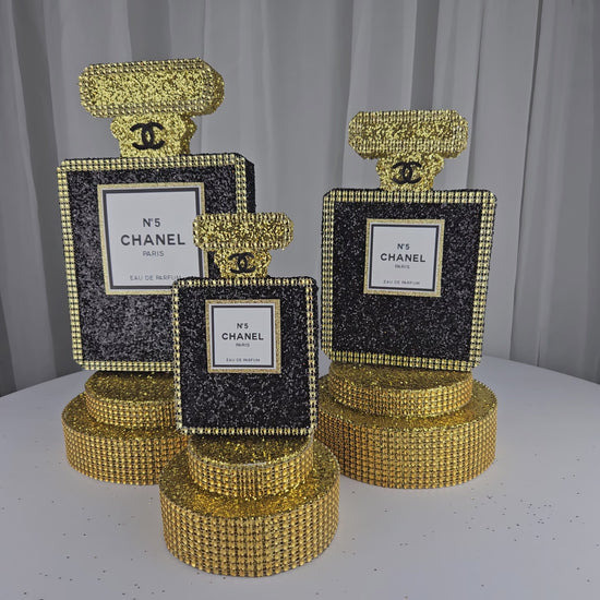 Chanel-inspired perfume bottle centerpiece in black and gold for glam birthday decor