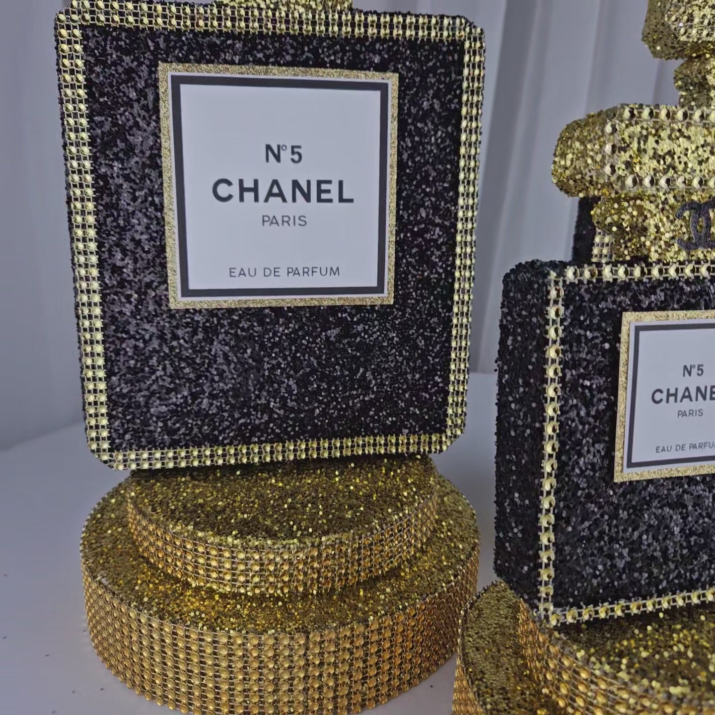 Luxury Chanel party perfume centerpiece with black glitter and gold glam base